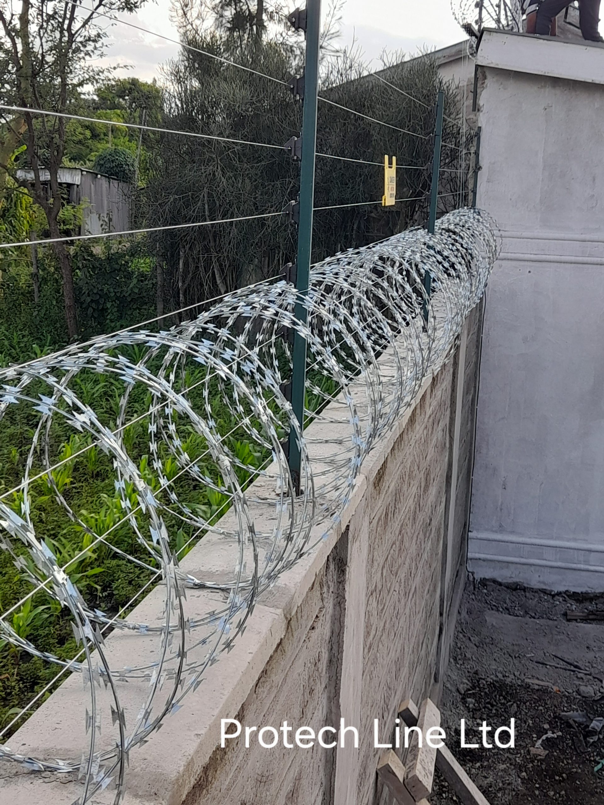 Electric fence with razor wire on wall installation in Kenya